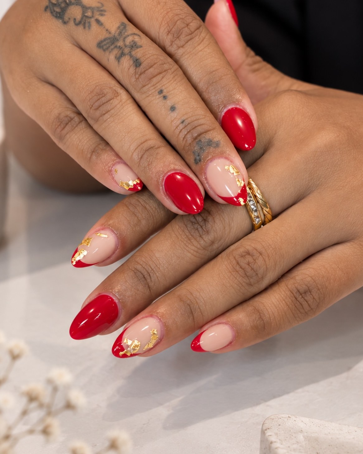Rode amandelnagels met een gouden rand en bladgoud