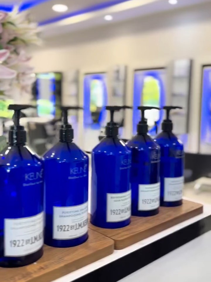 Blauwe flessen Keune haarverzorging op de plank in de salon